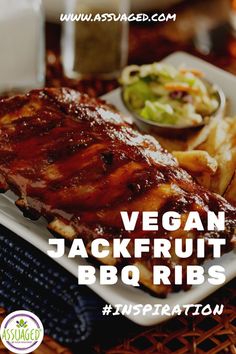 a white plate topped with ribs and fries next to a bowl of coleslaw