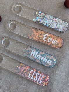 four personalized bottle openers with glitter on them