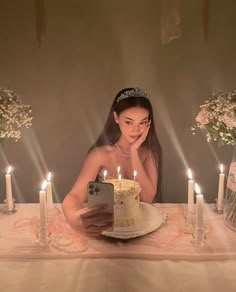 a woman sitting in front of a cake with candles on it