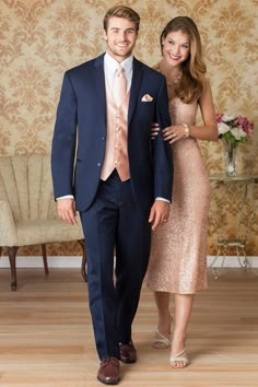 a man and woman in formal wear standing next to each other on a wooden floor