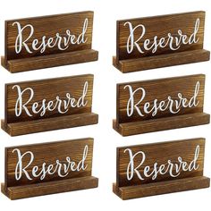 four wooden signs with the words reserved and reserved written in white ink on wood planks