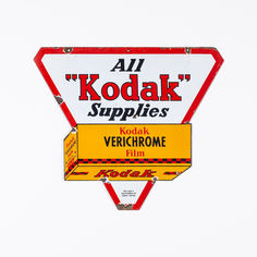 a red and white sign that says all kodak supplies on it's side