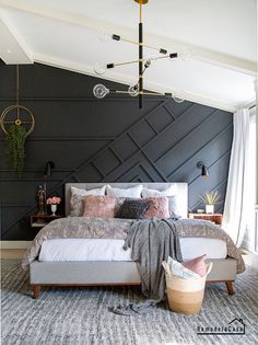 a bedroom with black walls and white bedding in the corner, along with a chandelier