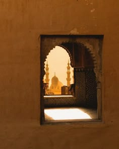 an open doorway with a view of a mosque in the distance and sunlight coming through