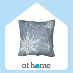 a blue and white snowflaked pillow with the words at home on it