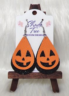 an orange and black pair of earrings with jack - o'- lanterns on them