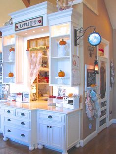 a kitchen with white cabinets and lots of cupboards on the wall, including an oven