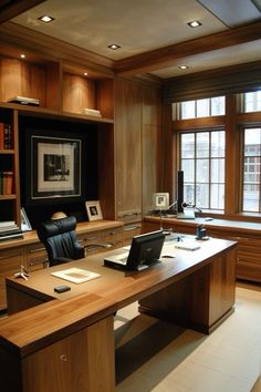 a desk with a laptop on top of it in front of a window and bookshelf