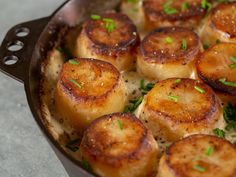 cooked scallops in a skillet with parsley on top