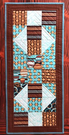 a blue and brown quilt on a wooden surface