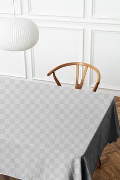 a table with a gray checkered cloth on it and a wooden chair in the background