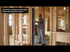 a man is standing in the middle of a room with wood framed walls and framing