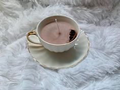 a white cup filled with liquid on top of a saucer