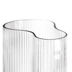 an empty glass vase sitting on top of a white tableclothed surface with lines drawn across the bottom