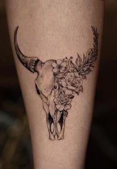 a cow skull with flowers on it's side