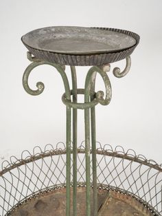 an old metal stand with a bowl on it