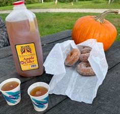 doughnuts, coffee and apple cider on a picnic table