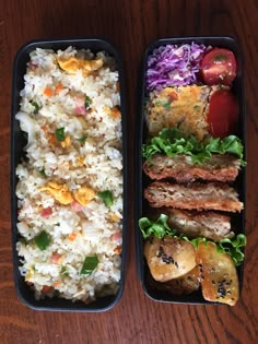 two black trays filled with food on top of a wooden table next to each other