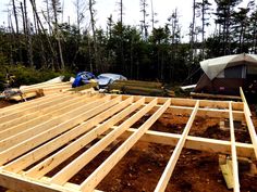 a house being built in the woods with lots of wood framing on top of it