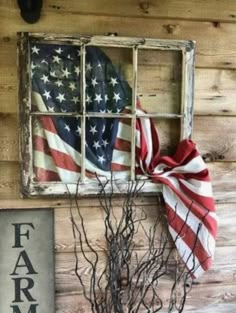 an old window is decorated with american flags and branches in front of the sign that says farm