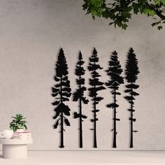 a group of trees that are next to a potted plant in front of a wall