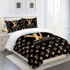 a bed with black and gold louis vuitton comforter set on top of it