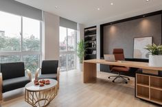 an office with two chairs and a desk in front of large windows