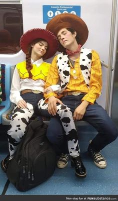 two people dressed in costumes sitting on a subway train together, one wearing a cowboy hat and the other as a cowgirl