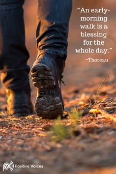 a person walking down a dirt road with a quote on it