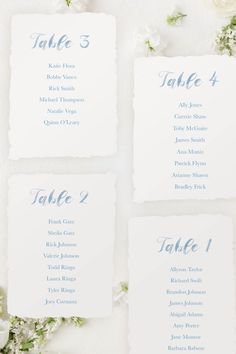 the table numbers are displayed in blue ink on white paper, with flowers around them