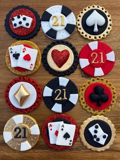 some casino themed cupcakes are on a wooden table with gold and black decorations