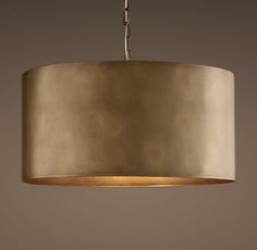 a light fixture hanging from a ceiling with a beige shade on the top and bottom