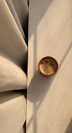 a small bowl sitting on top of a white sheet