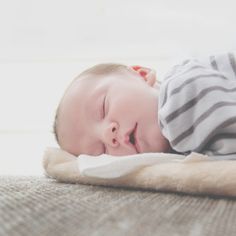 a baby sleeping on top of a blanket