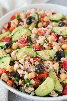 mediterranean tuna salad with cucumbers, tomatoes and olives in a white bowl