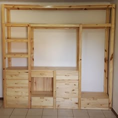 an empty room with wooden shelves and shelving unit in it's center area