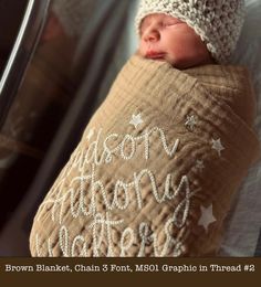 a newborn baby wrapped in a blanket and wearing a crochet hat with stars on it