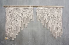 two macrame wall hangings on a concrete wall