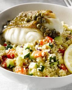 a white bowl filled with fish and vegetables