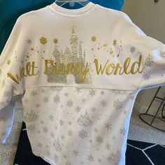 a white t - shirt that says walt world with gold lettering on the front and back