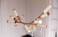 a modern chandelier hanging from the ceiling in a room with white walls and flooring