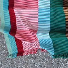 a multicolored blanket laying on the ground