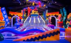 an inflatable water slide with colorful decorations and lights on the ceiling is lit up at night