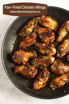 chicken wings in a skillet with parsley on the side and text overlay that reads pan - fried chicken wings