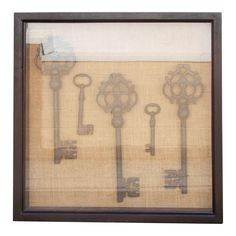 five antique keys are hanging in a shadow box