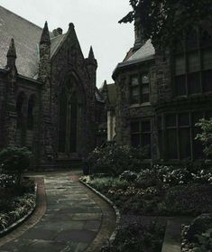 an old building with many windows and flowers in the front yard