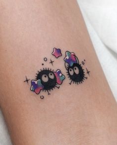 two small black birds with stars on their foreheads tattooing each other's eyes