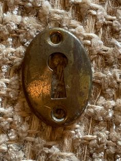 an old key is attached to a piece of fabric that looks like it has been woven in