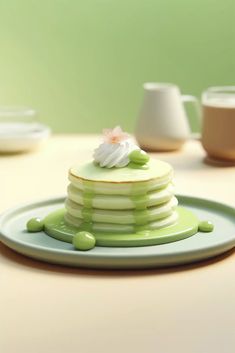 a stack of green and white pancakes sitting on top of a plate next to cups