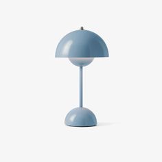 a blue table lamp sitting on top of a white floor